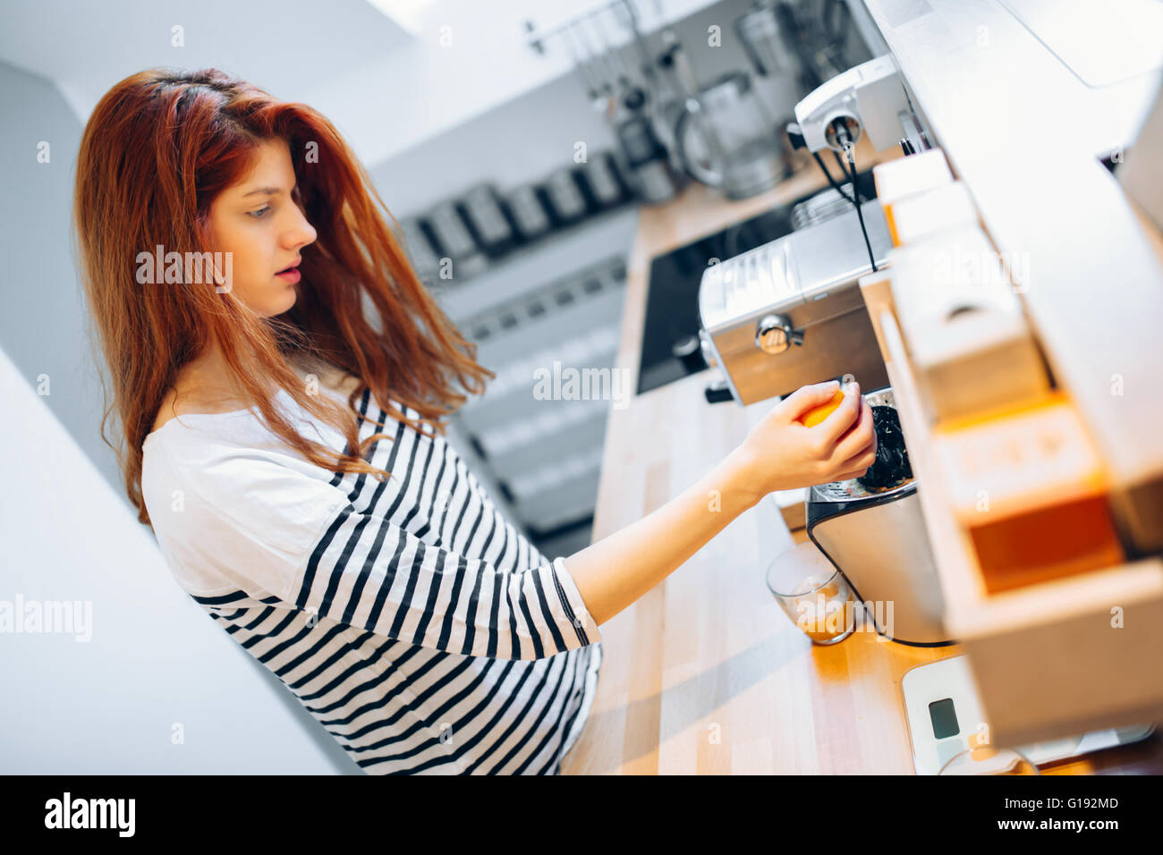 Beautiful woman making orange juice with blender in kitchen Stock Photo Alamy