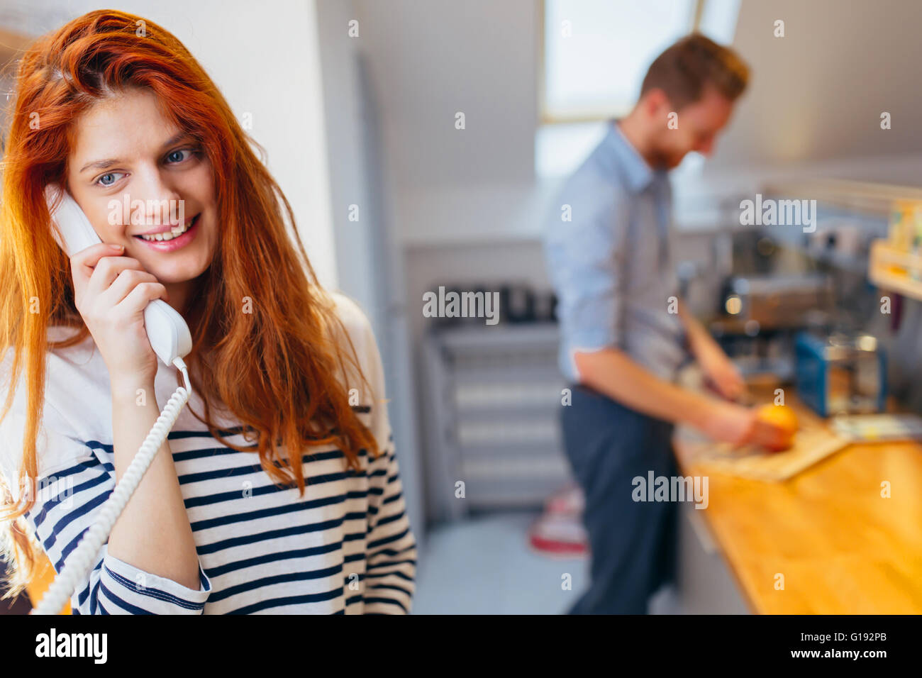 Beautiful woman talking to arriving guests on intercom Stock Photo