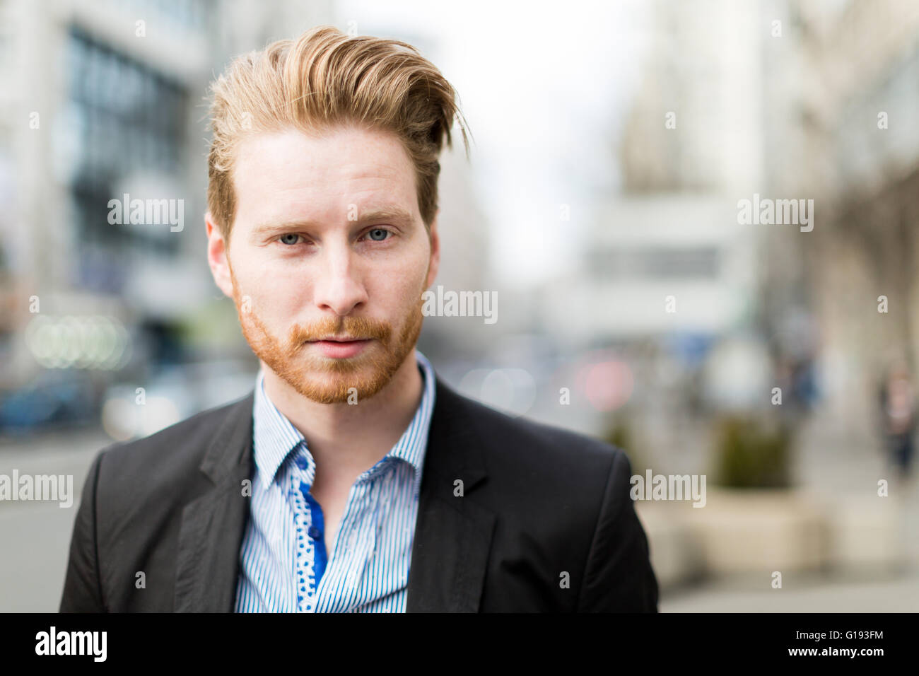 Businessman portrait with blurred out city buildings in the background Stock Photo