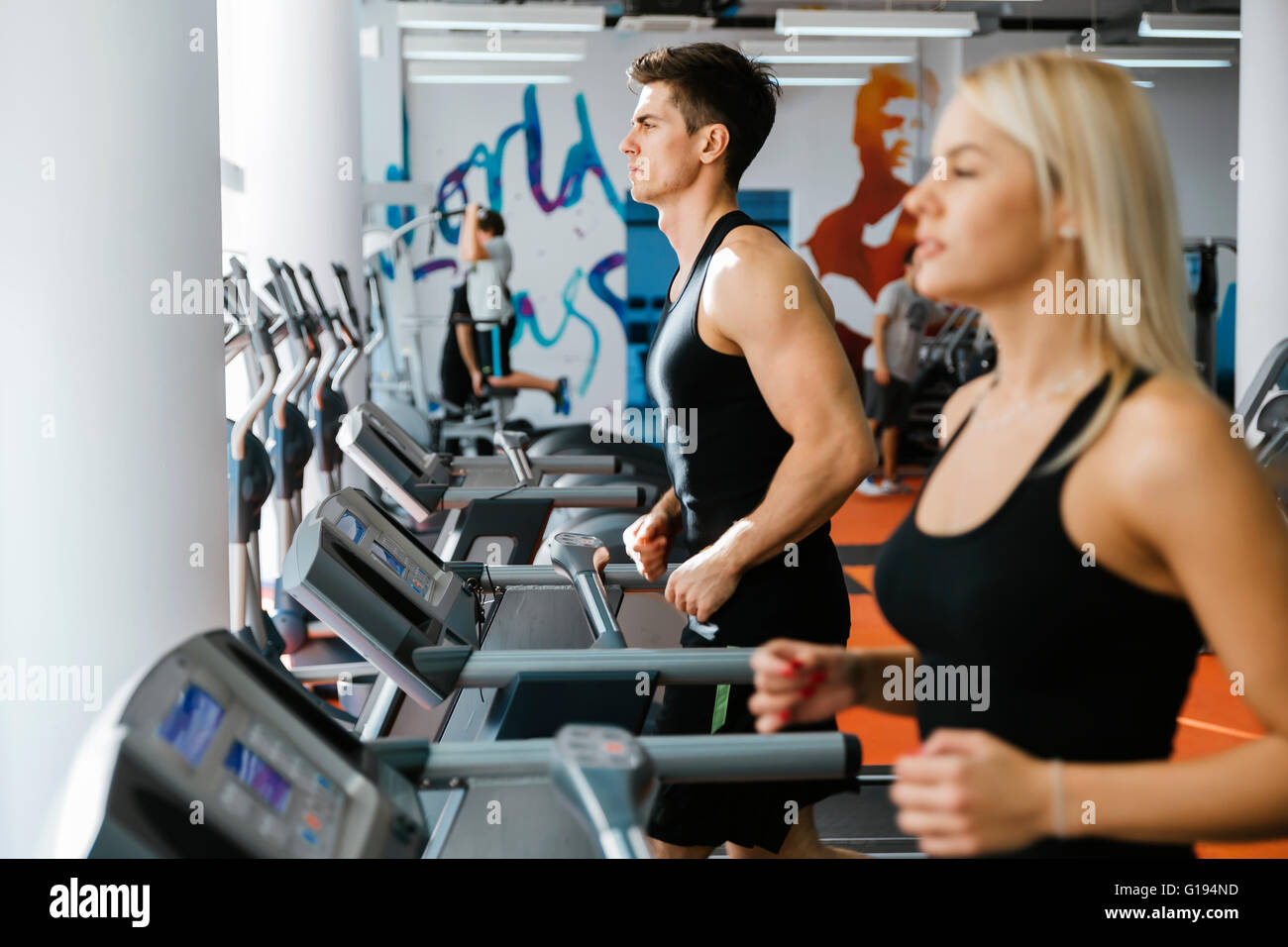 People running on treadmills in gym to keep body in shape Stock Photo