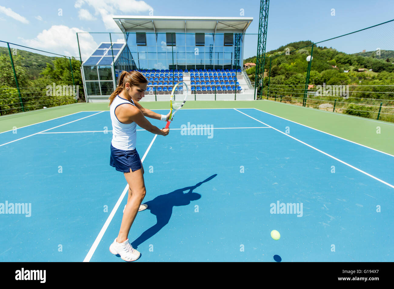 Female tennis player performing a drop shot on a nice blue court Stock Photo