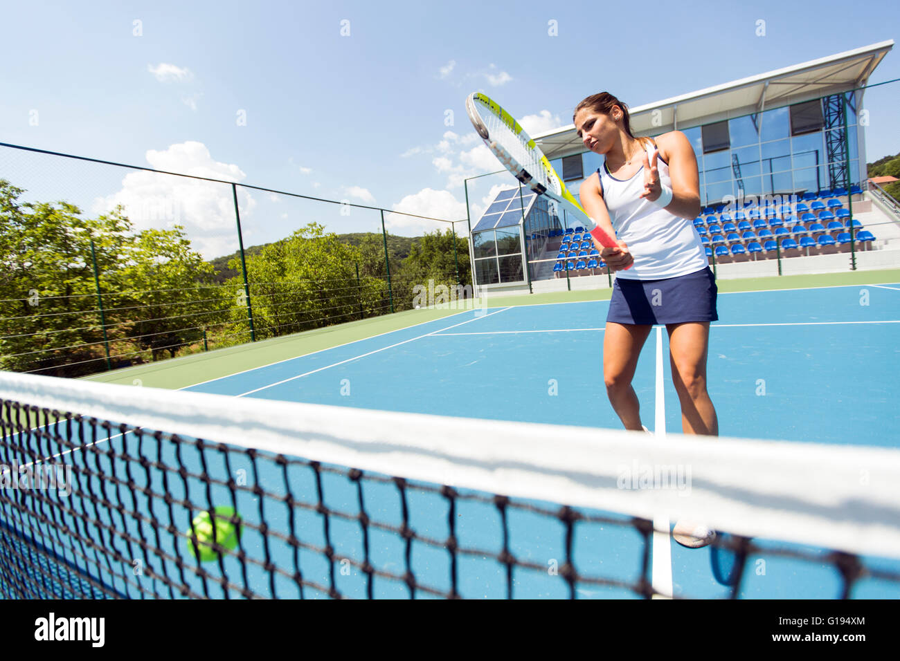 Female tennis player hitting the net and losing the point Stock Photo