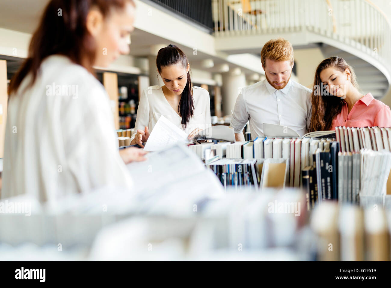 Group of students studying in library and reading books Stock Photo