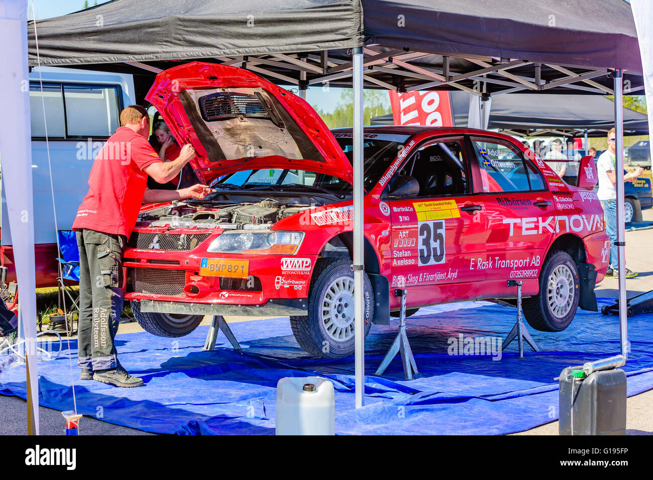 Emmaboda, Sweden - May 7, 2016: 41st South Swedish Rally in service depot. Crew working on red Mitsubishi EVO IX at team Adolfss Stock Photo