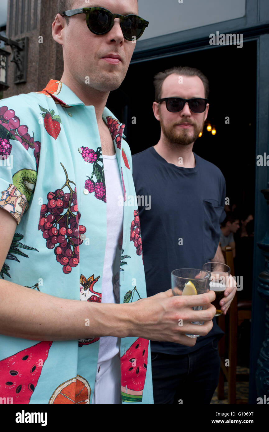 Hackney. Broadway market. Cat and mutton pub. Two men with drinks, one wearing a summer colorful shirt Stock Photo