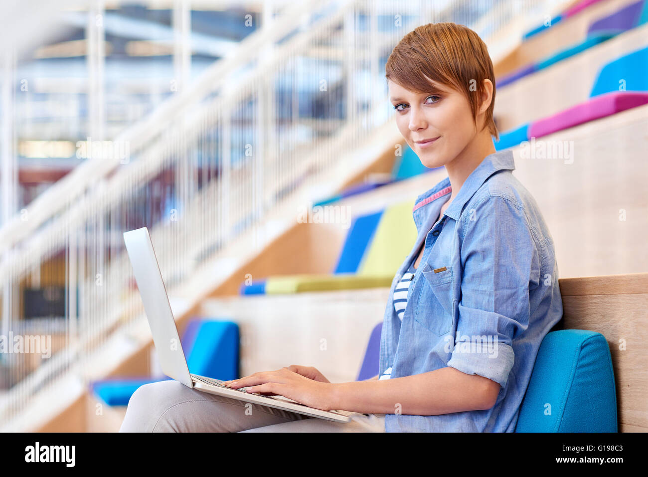 Portrait of a pretty young female student smiling gently at the camera ...