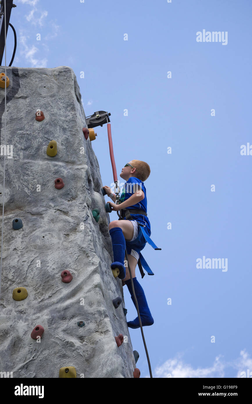 Trying to reach the top of a climbing wall and ring the bell signaling