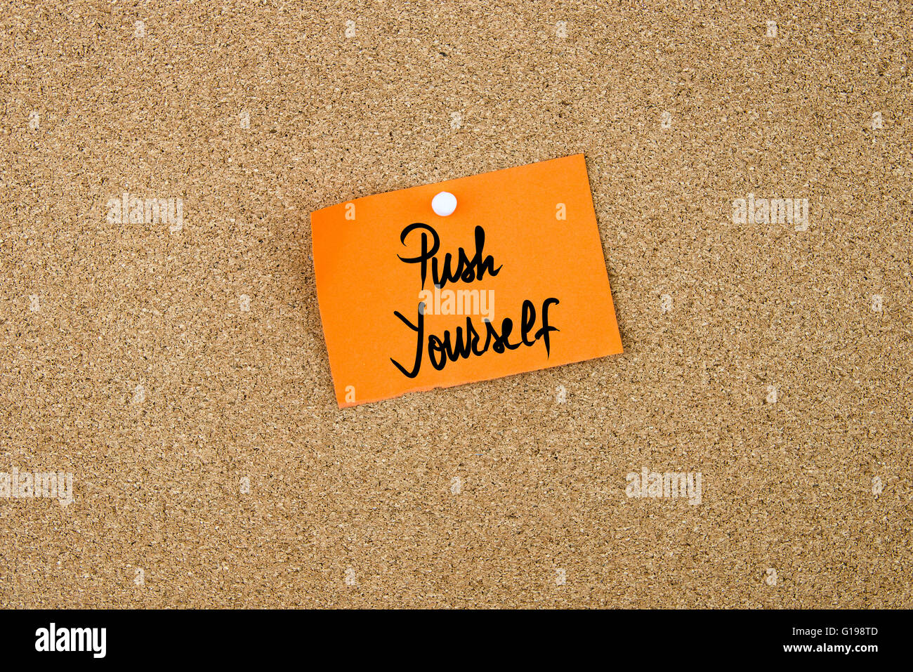 Push Yourself written on orange paper note pinned on cork board with white thumbtacks, copy space available Stock Photo