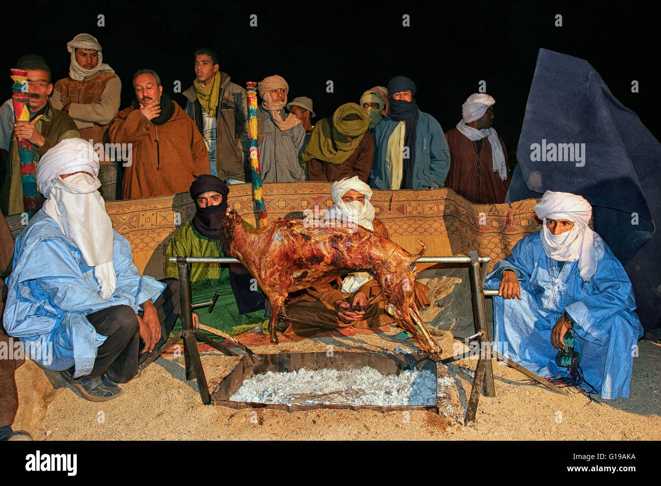 Tuareg preparing a roast lamb grilled in TAFSIT festival. Algeria, Sahara, Hoggar (Ahaggar Mountains), Tamanrasset Stock Photo
