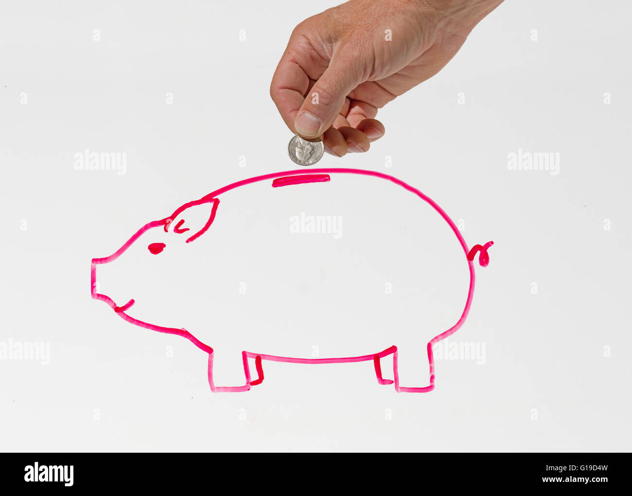 a mans hand putting a coin into a drawing of a piggy bank in pink on a whiteboard Stock Photo