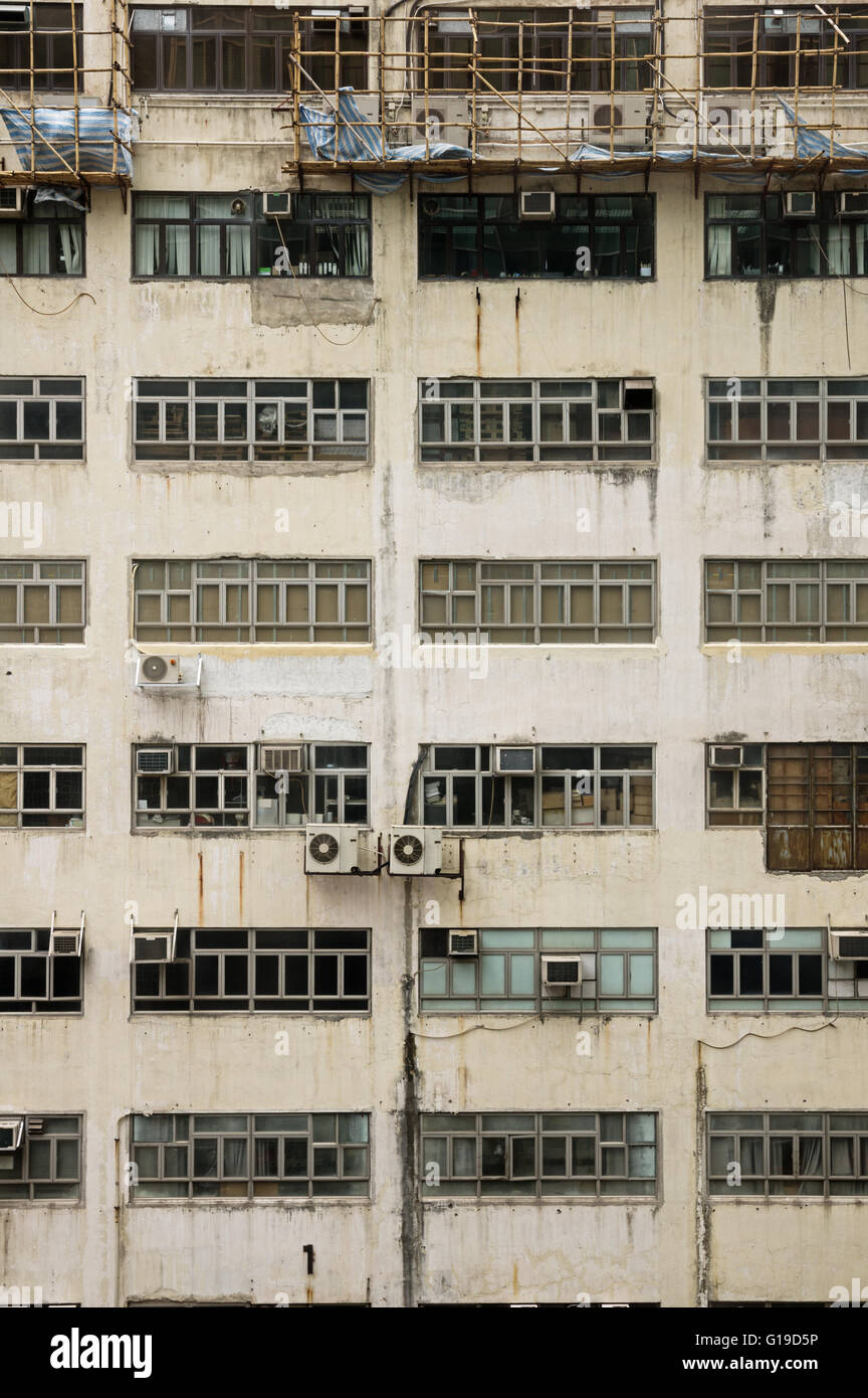 dingy building side with windows window air conditioning units