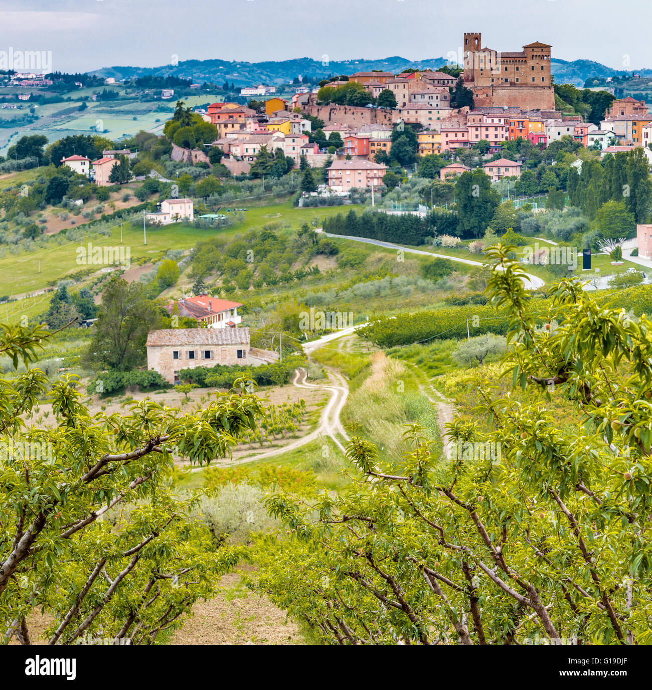 the medieval castle overlooking the hilly countryside surrounding the colorful houses of the charming mountain town of Longiano, near Cesena, Italy Stock Photo