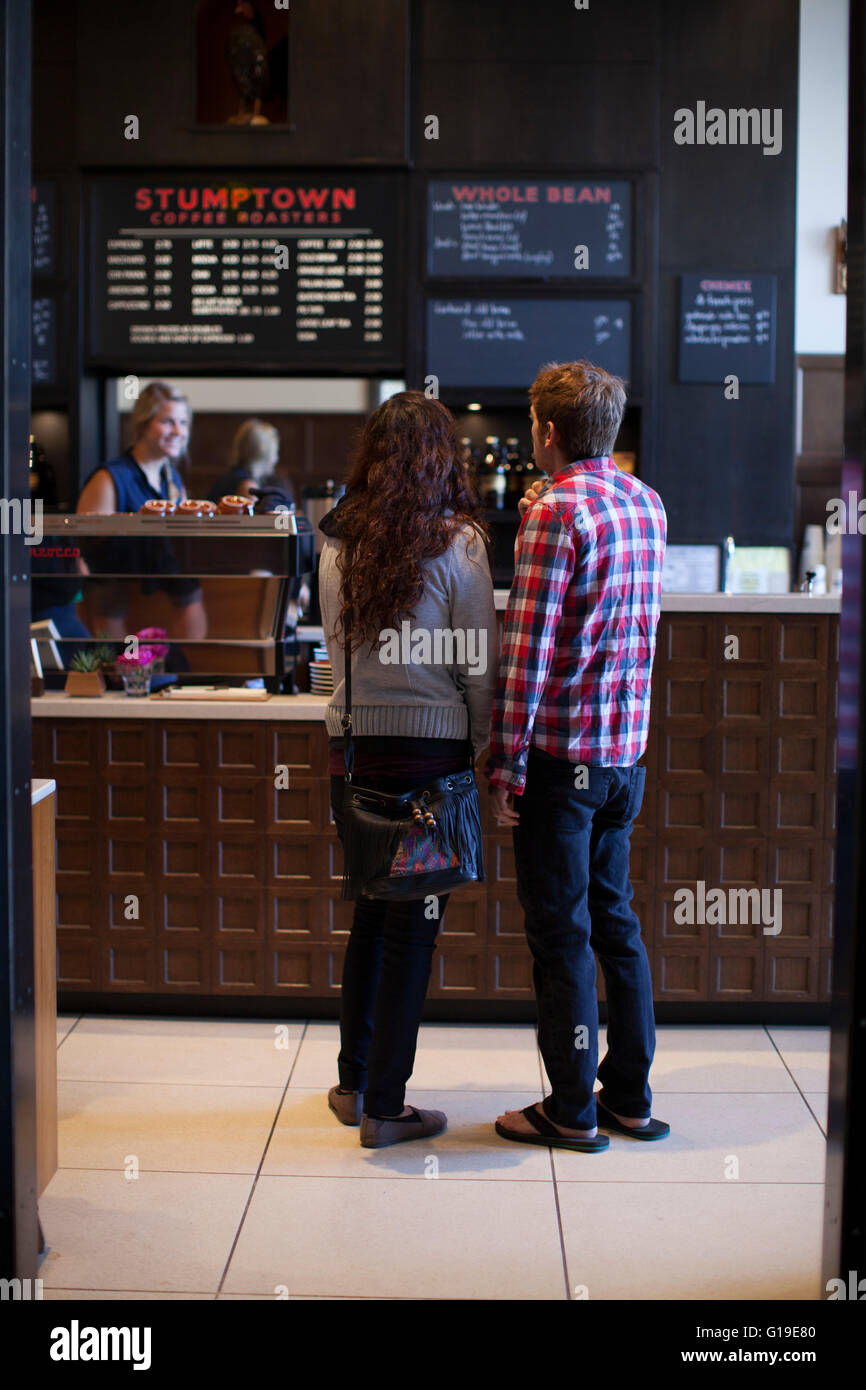 A couple order coffee at a popular cafe in a city. Stock Photo