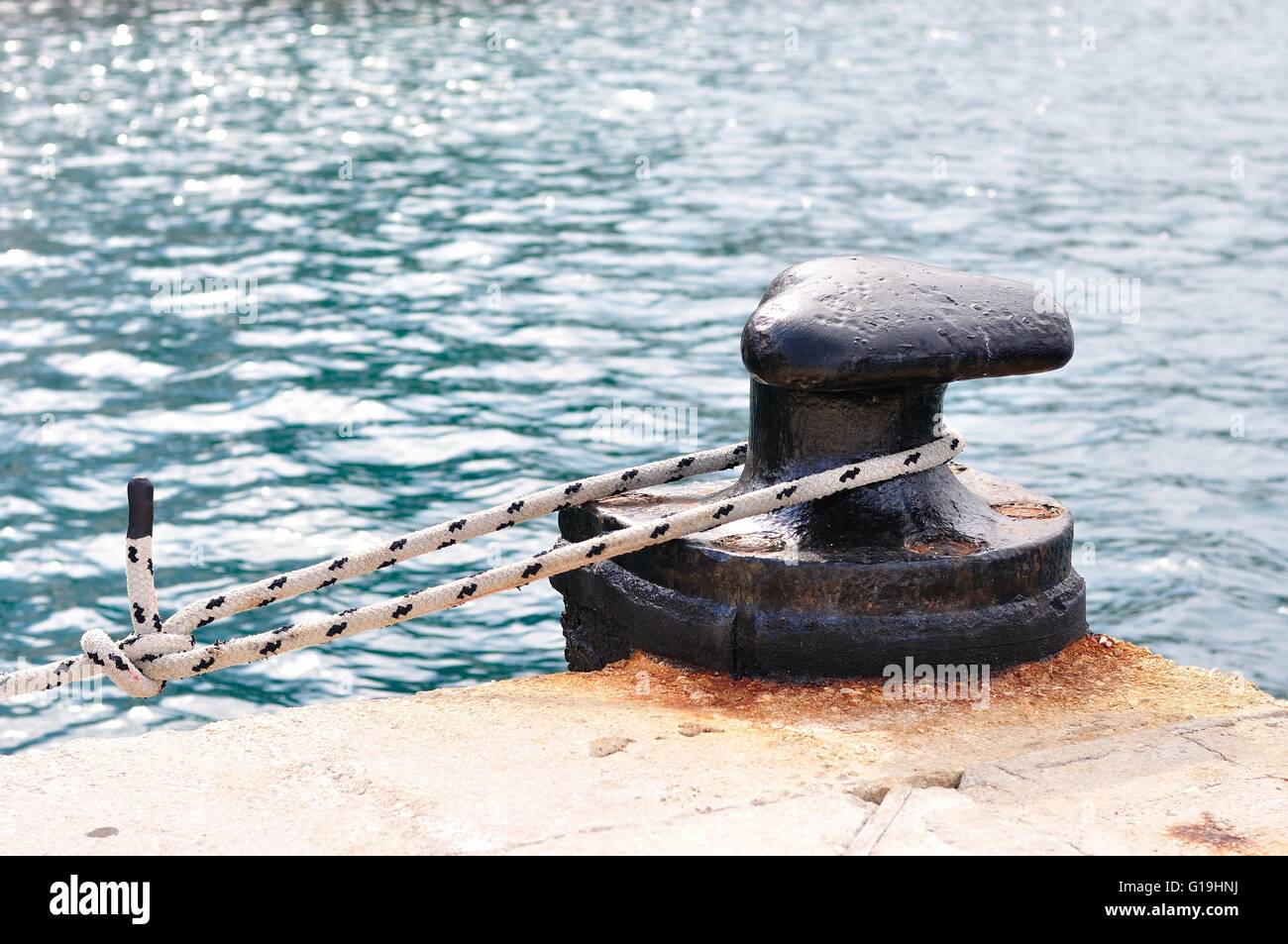 Marine rope on mooring bollard in port of Podgora, Croatia Stock Photo