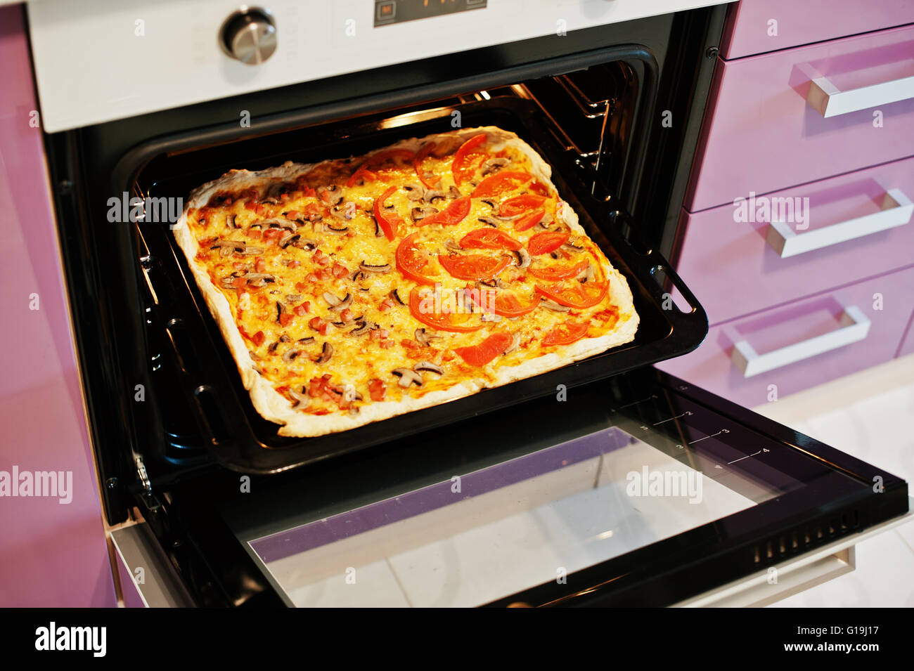 Homemade pizza in electric oven in the kitchen Stock Photo Alamy