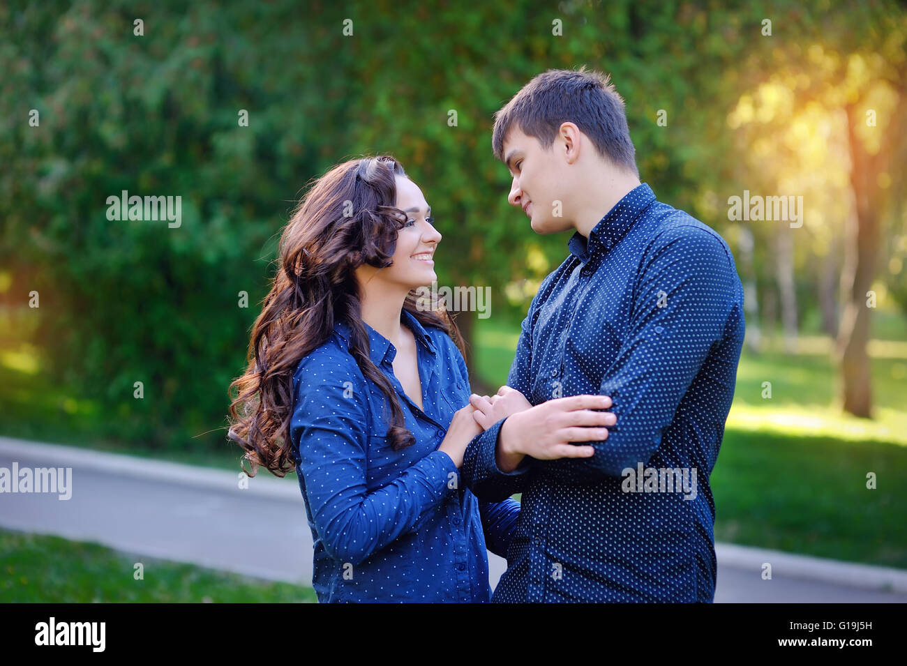 Couple hugging in a park seated in a bench Stock Photo - Alamy