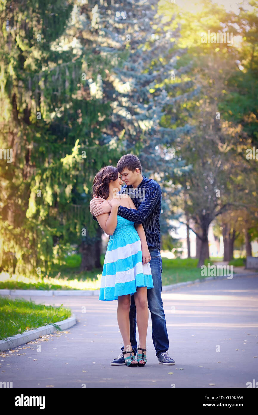 young couple kissing while sitting in a summer forest Stock Photo