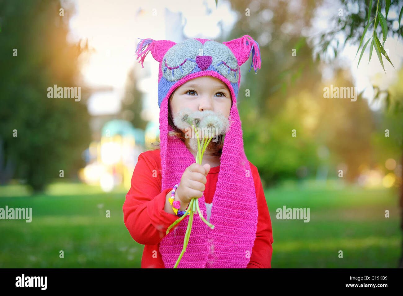 beautiful girl blowing on white dandelion, smile Stock Photo