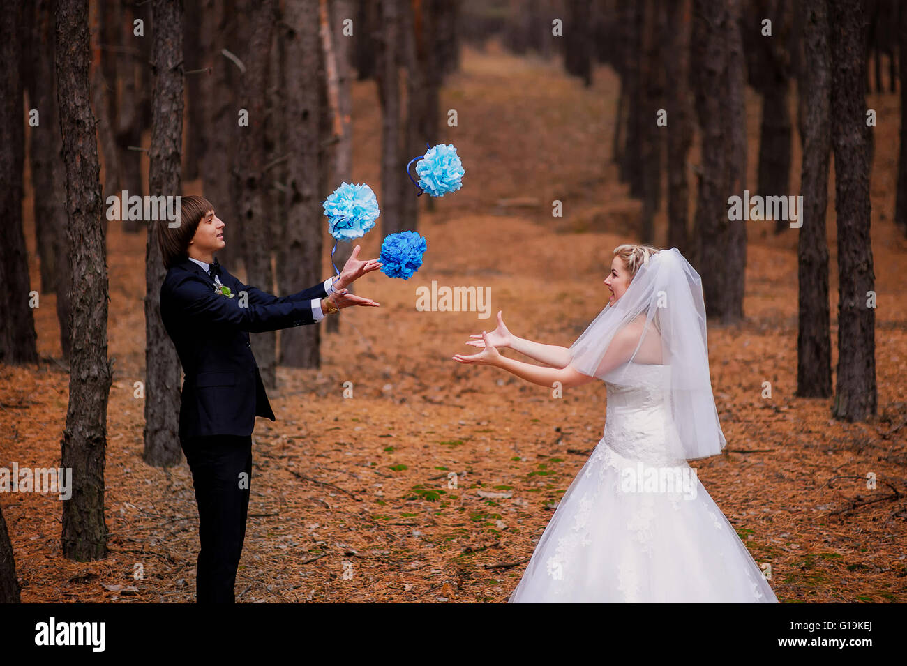 bride and groom playing in the woods Stock Photo