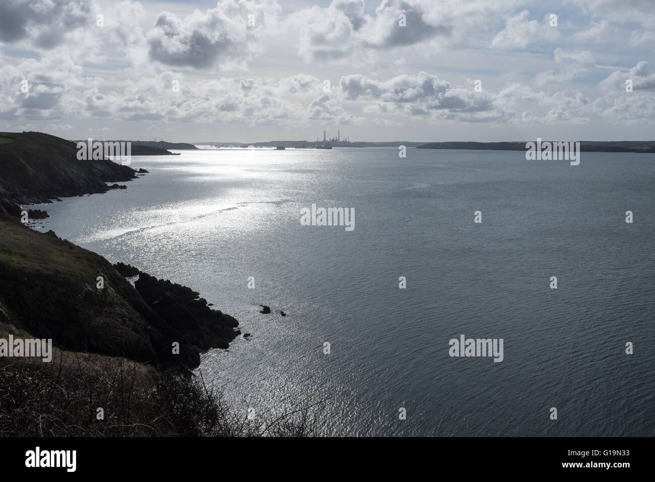Pembrokeshire Coastal Path near Dale with Milford Haven oil refinery in the distance Stock Photo