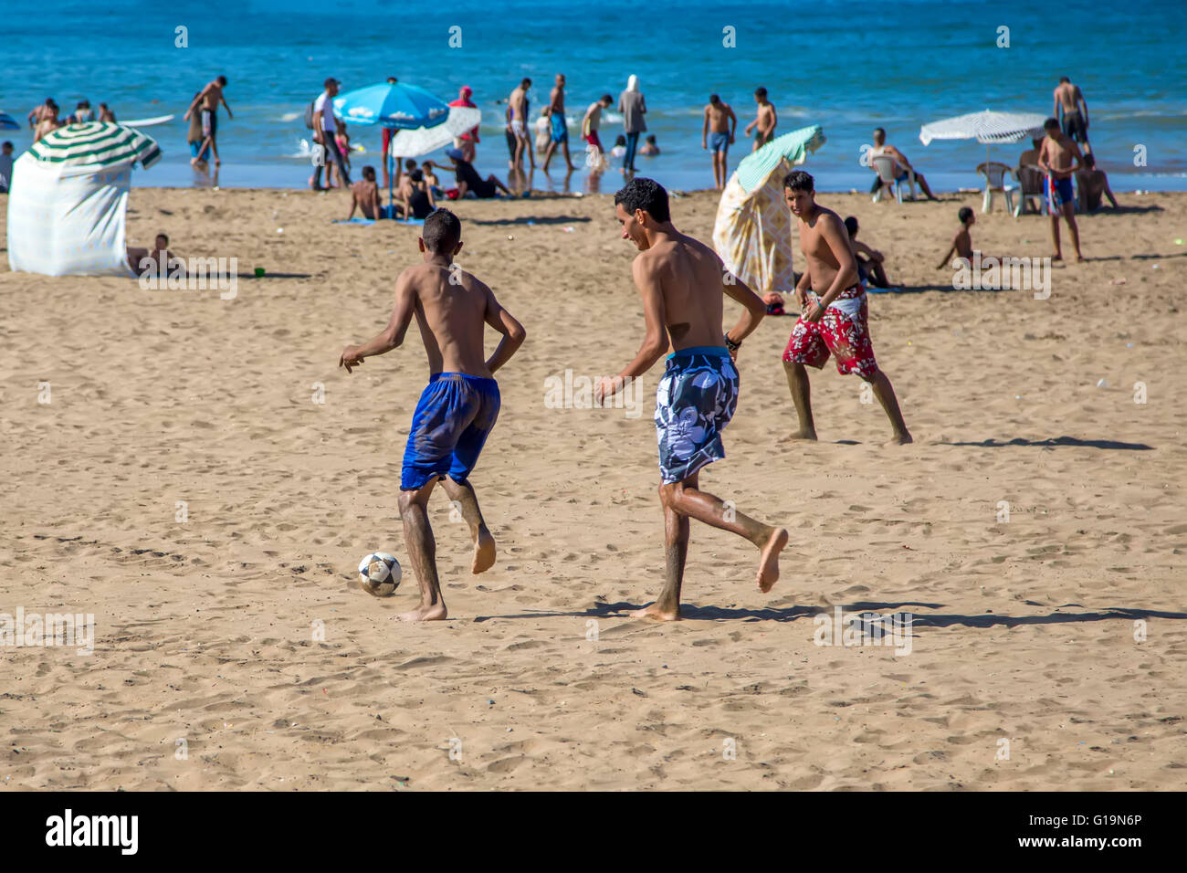 Unidentified people playing soccer at the beach. Soccer is a very popular sport in Morocco. Stock Photo