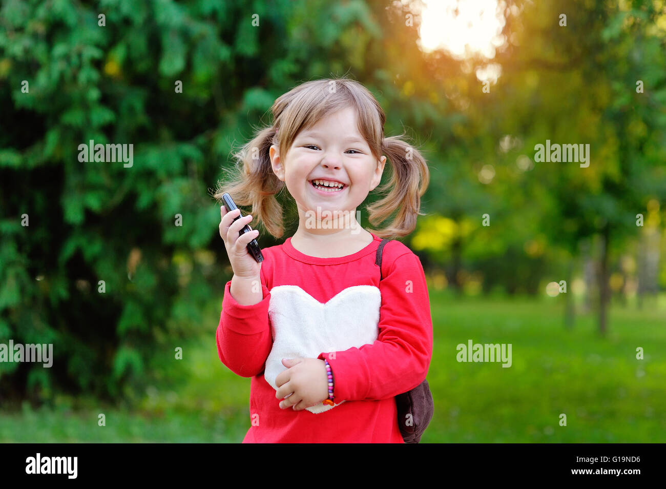 Happy girl talking on the phone in the park Stock Photo