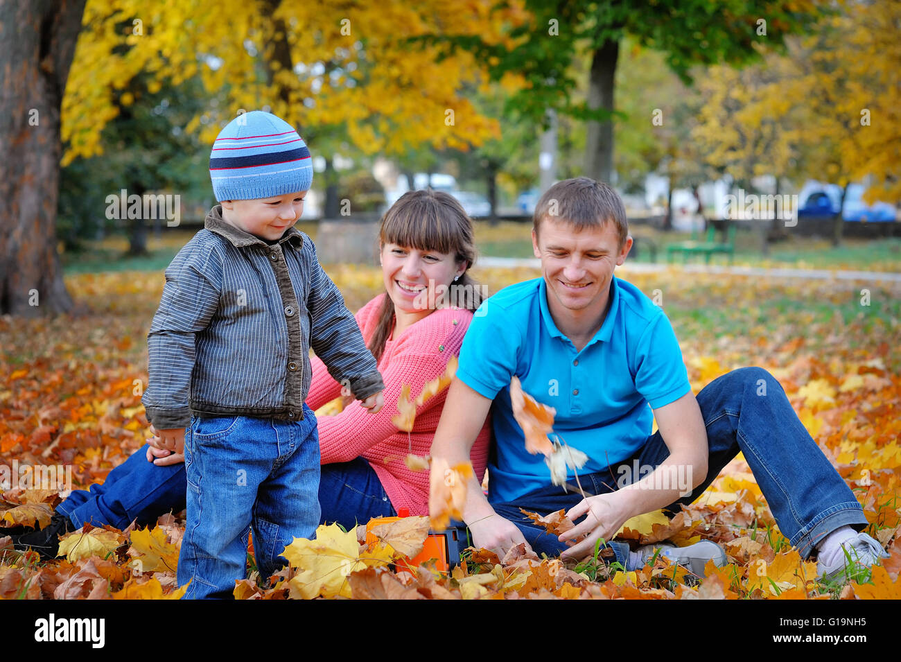 Happy family playing piggyback in autumn park Stock Photo