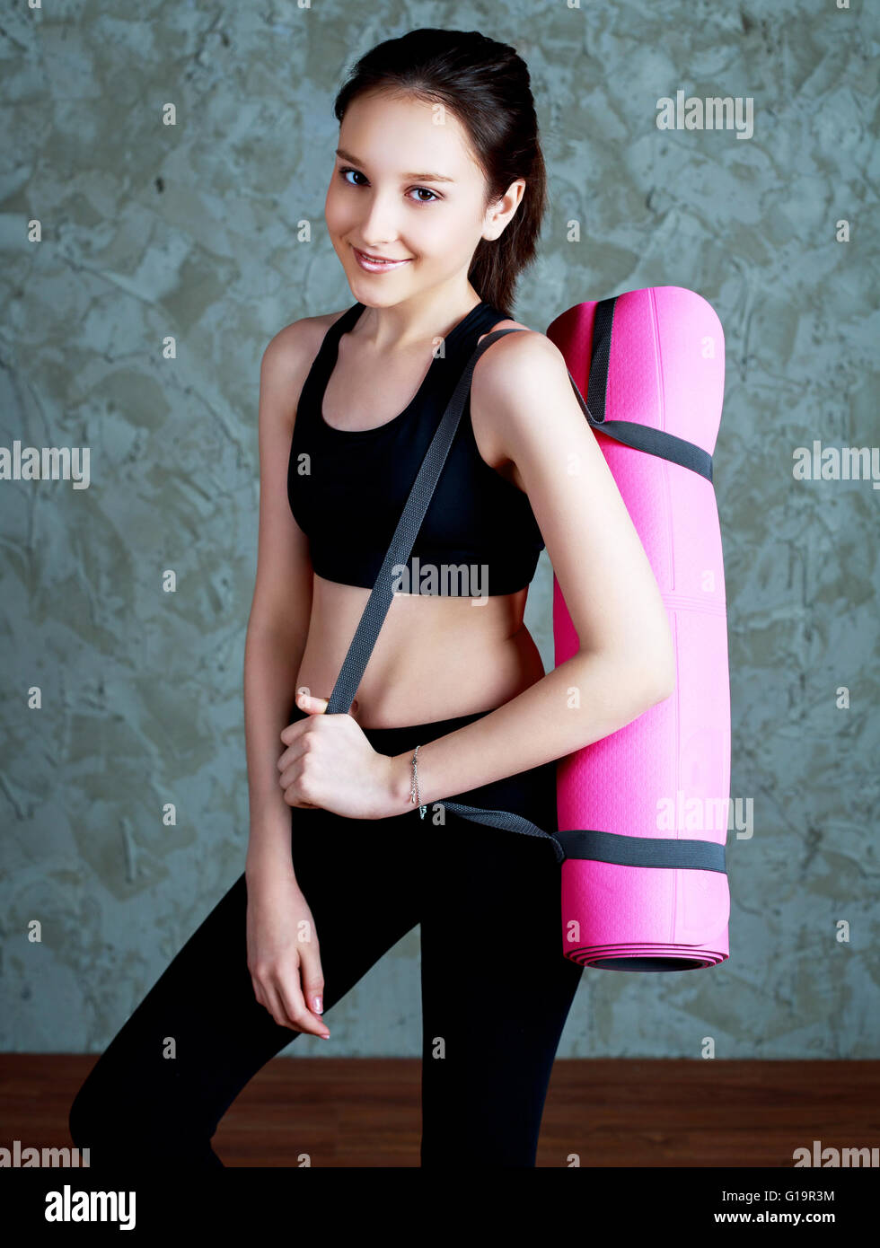 beautiful teenage girl with a yoga mat indoors Stock Photo - Alamy
