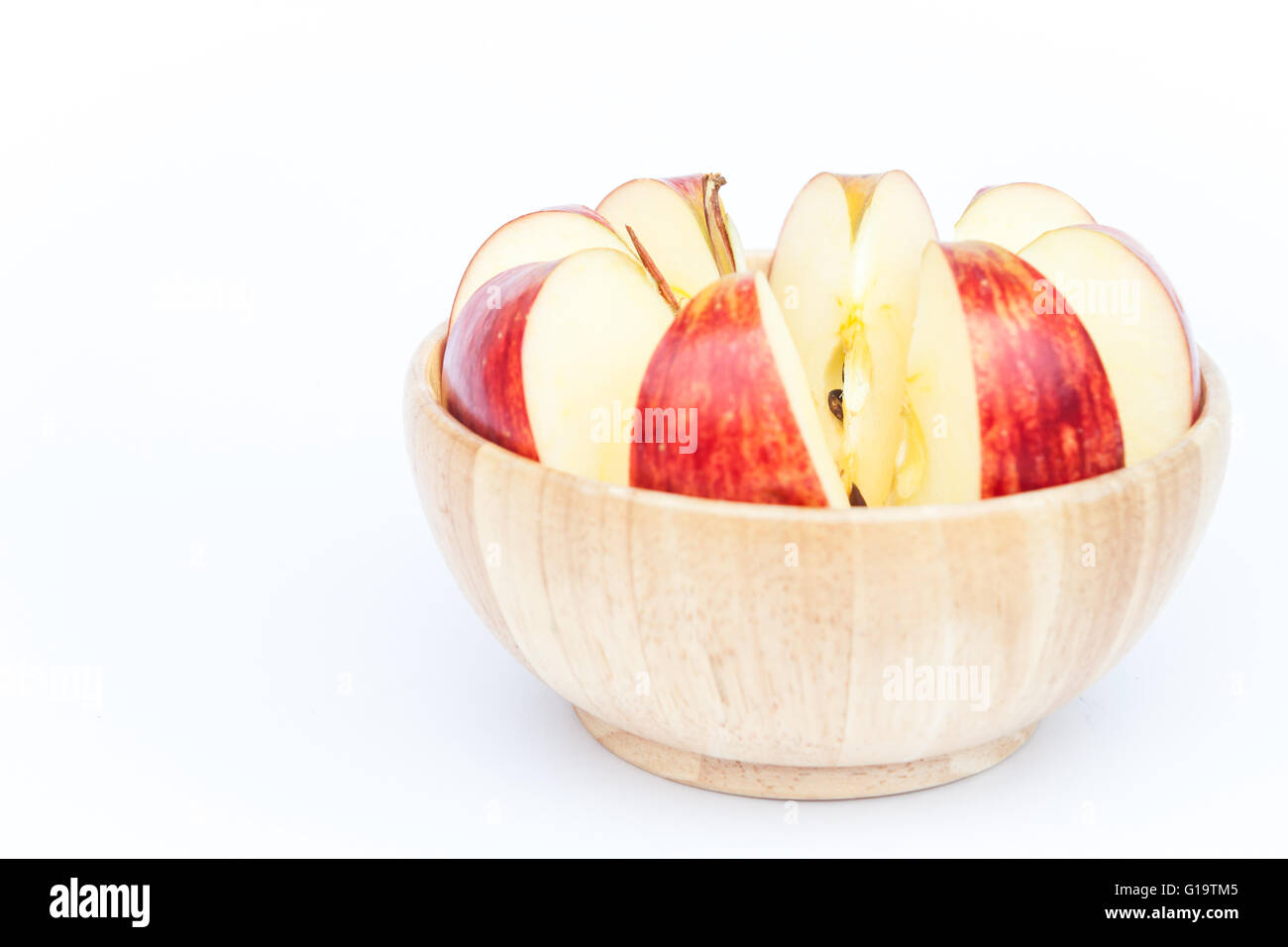 Sliced apple in wooden bowl on white background Stock Photo