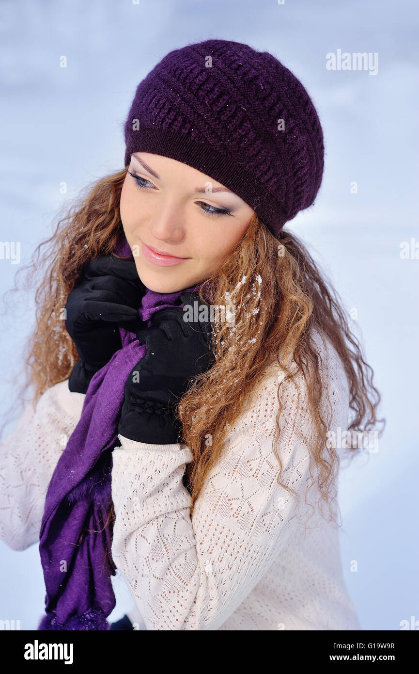 beautiful girl in a purple knitted winter hat and scarf Stock Photo