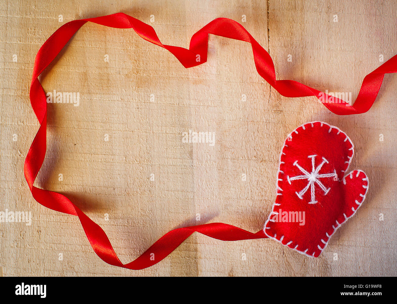 Christmas frame with Santa Claus mittens on a wooden background Stock Photo