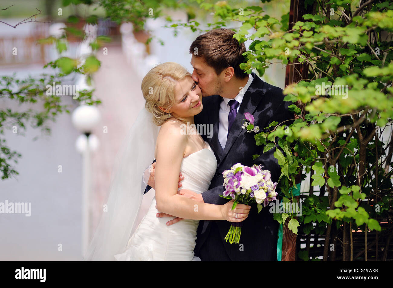 bride and groom kissing in the park happy Stock Photo - Alamy