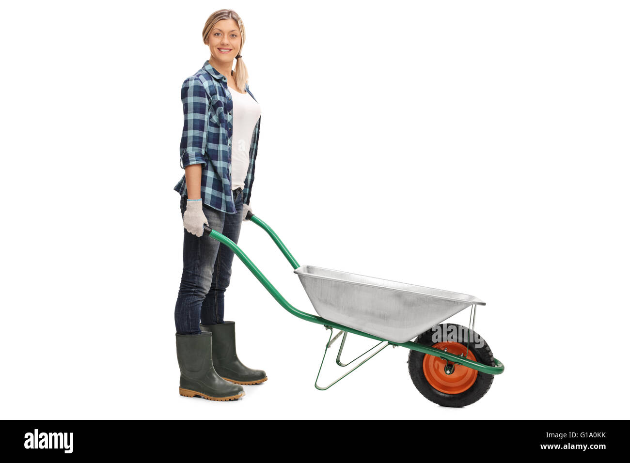 Cheerful woman posing with an empty wheelbarrow isolated on white background Stock Photo