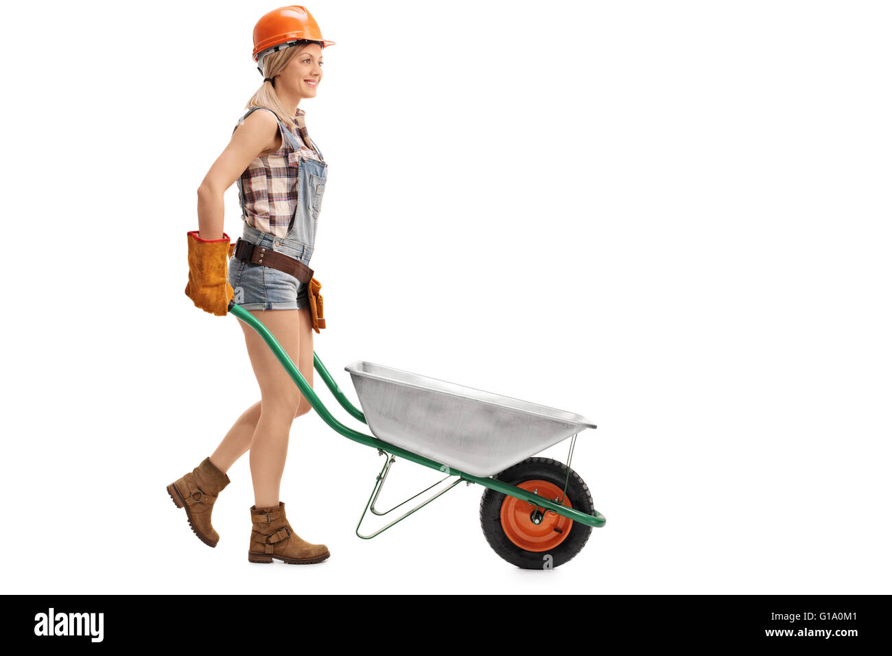 Female construction worker pushing an empty wheelbarrow isolated on ...