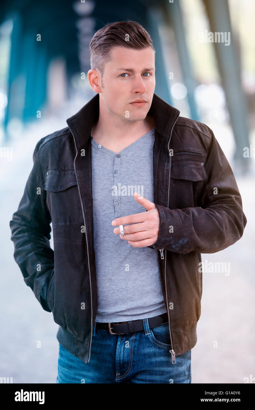 blond man in jeans walking the street and smoking a cigarette Stock Photo -  Alamy