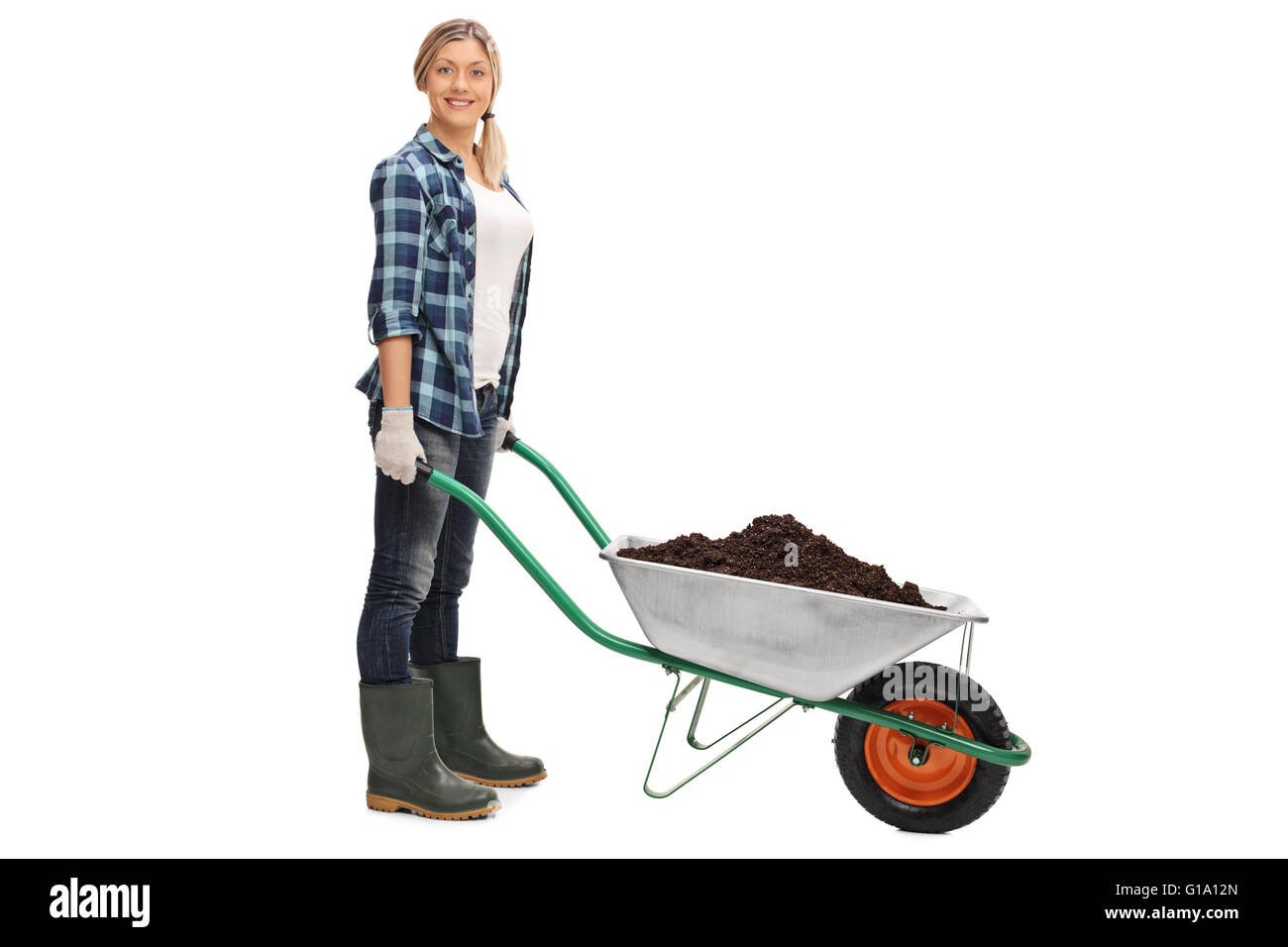 Young woman posing with a wheelbarrow full of dirt isolated on white background Stock Photo