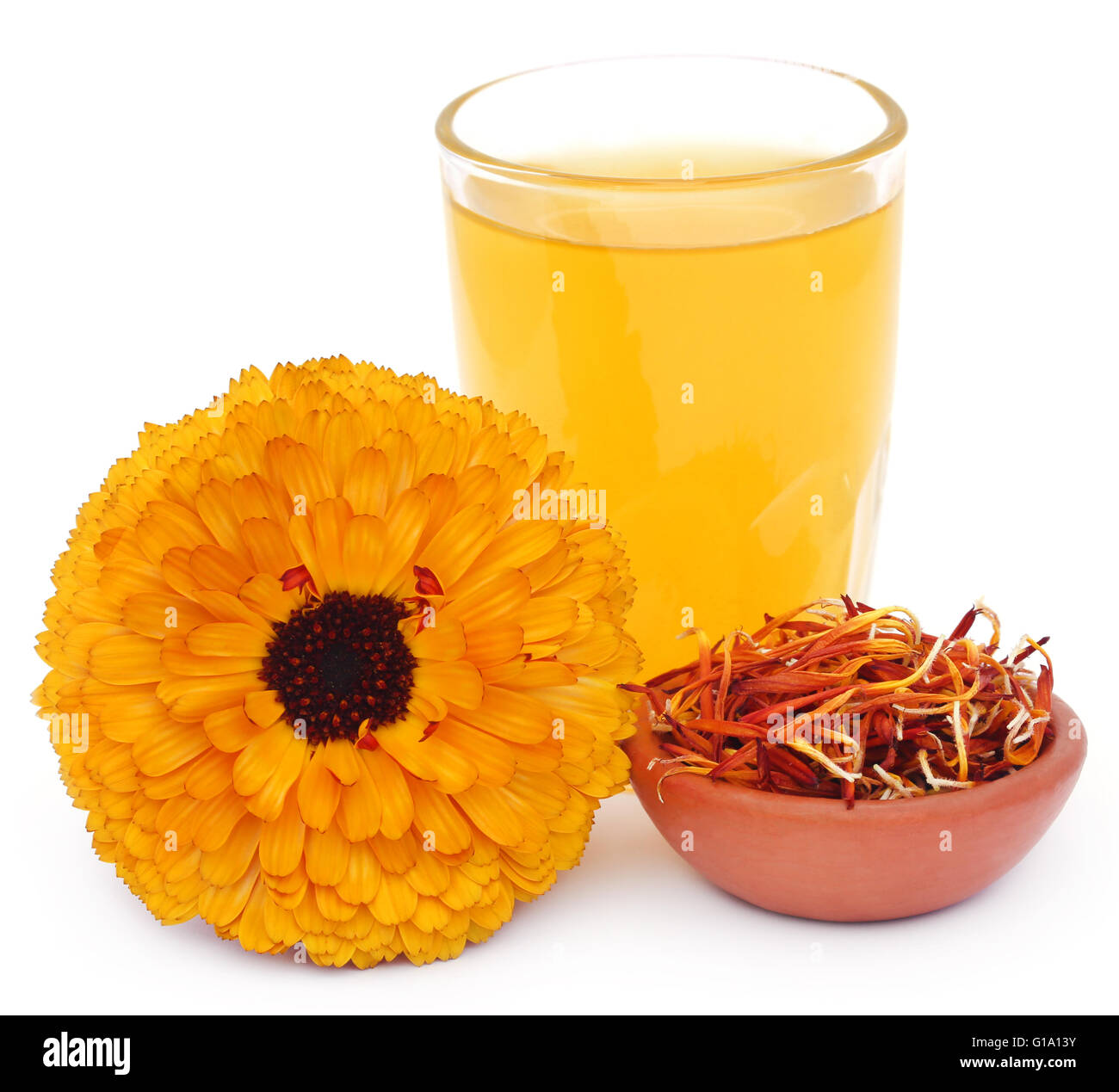 Herbal calendula flower with extract in a glass over white background Stock Photo
