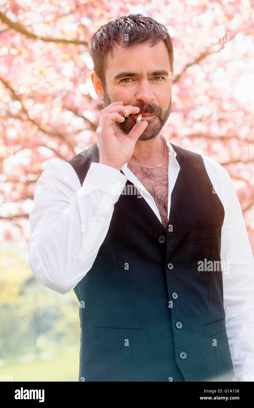 handsome businessman smoking a cigarette outside Stock Photo