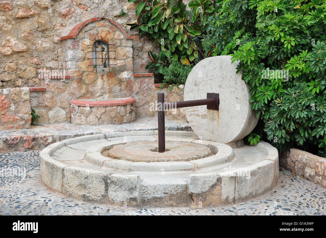 Ancient fountain and the stone oil press Stock Photo