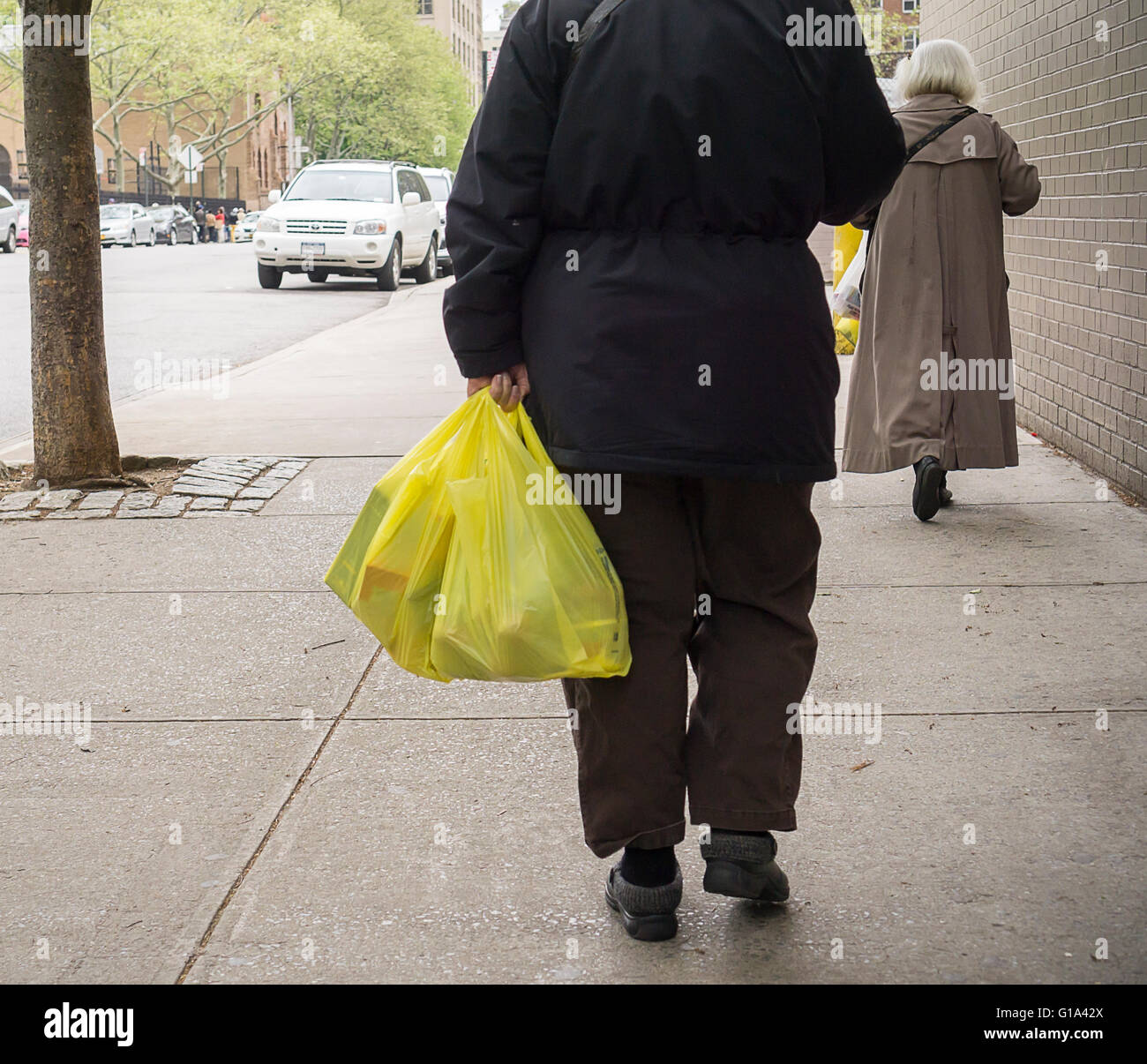 A shopper with her supermarket plastic bags in New York on Thursday, May 5, 2016. The New York City Council approved a bill to charge shoppers 5 cents for every bag used in order to encourage people to reuse or bring their own bags. (© Richard B. Levine) Stock Photo