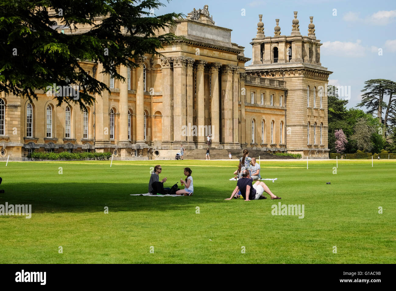 Visitors to Blenheim Palace relaxing on the lawn on a sunny day Stock Photo