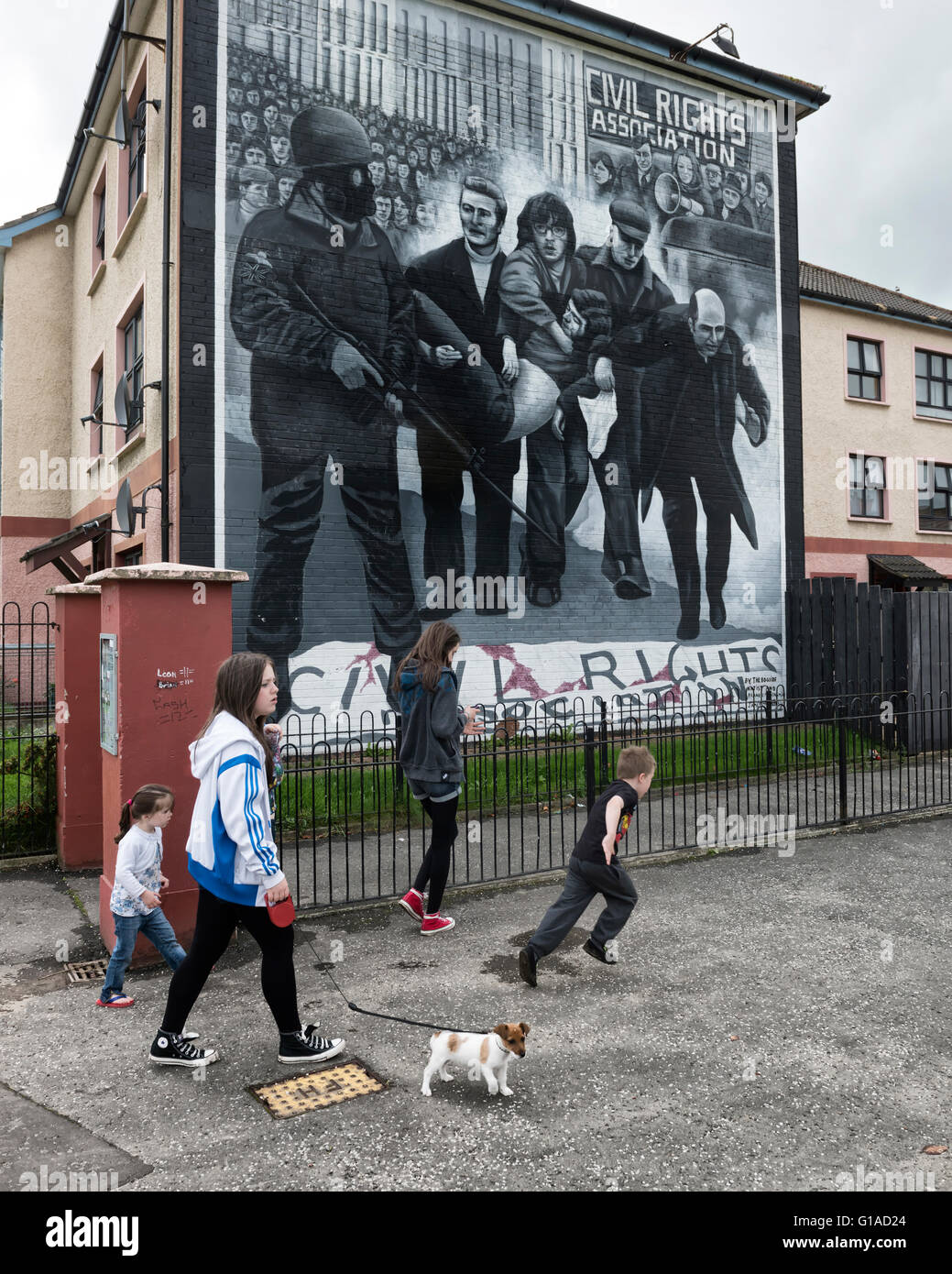 Local Catholic children passing the civil rights Bloody Sunday mural. Derry Londonderry. Northern Ireland. UK. Europe Stock Photo
