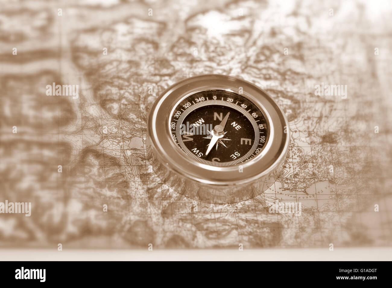 Tools for the journey - a map and a compass. Magnetic compass is located on a topographic map. Stock Photo