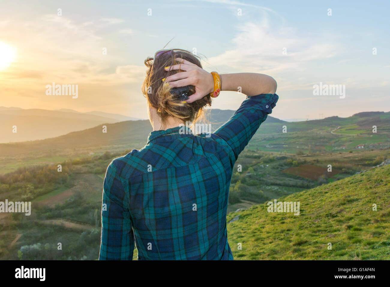 Girl on hiking trip enjoying the sunset view from above Stock Photo