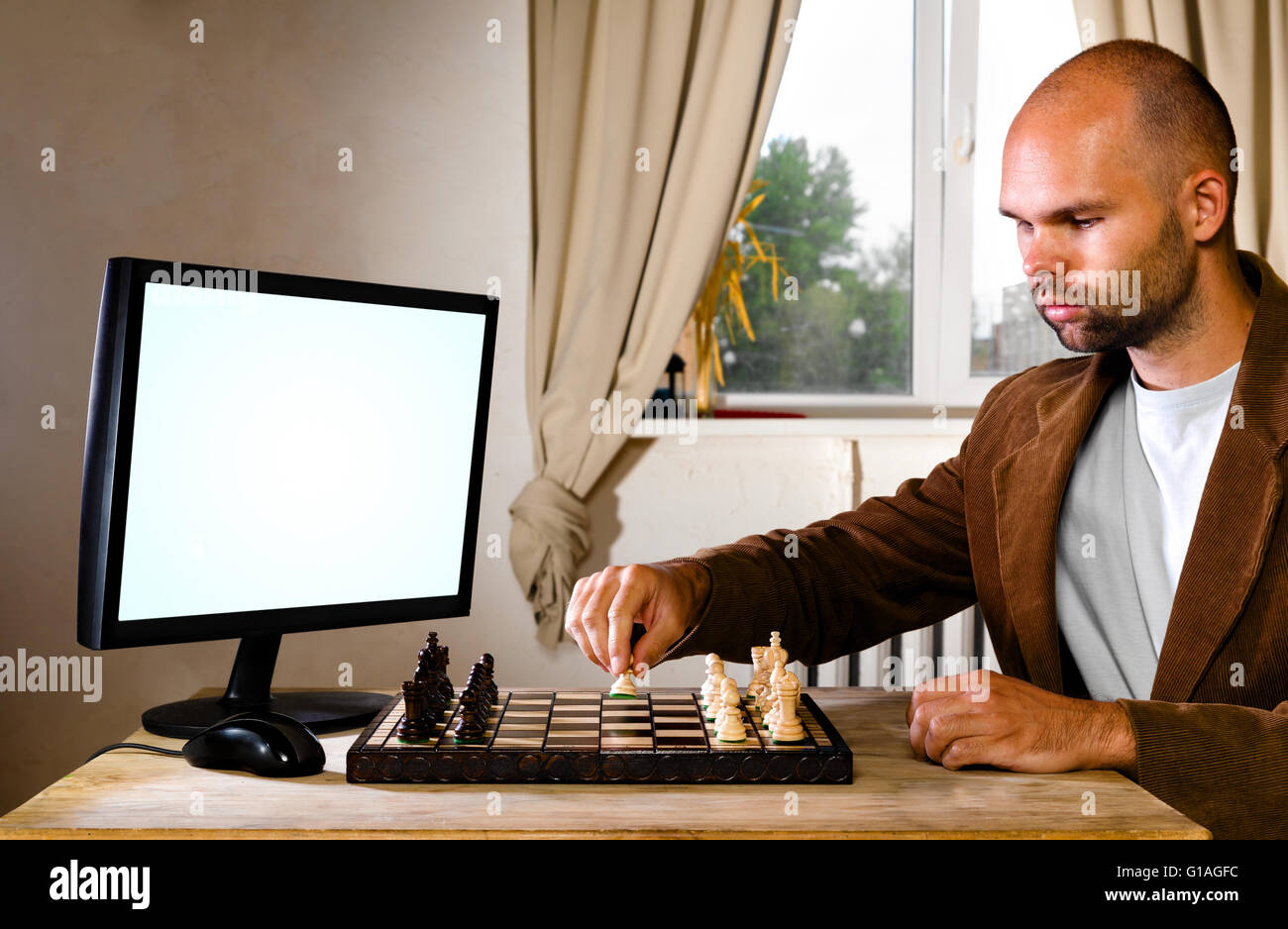 Caucasian man playing chess computer hi-res stock photography and