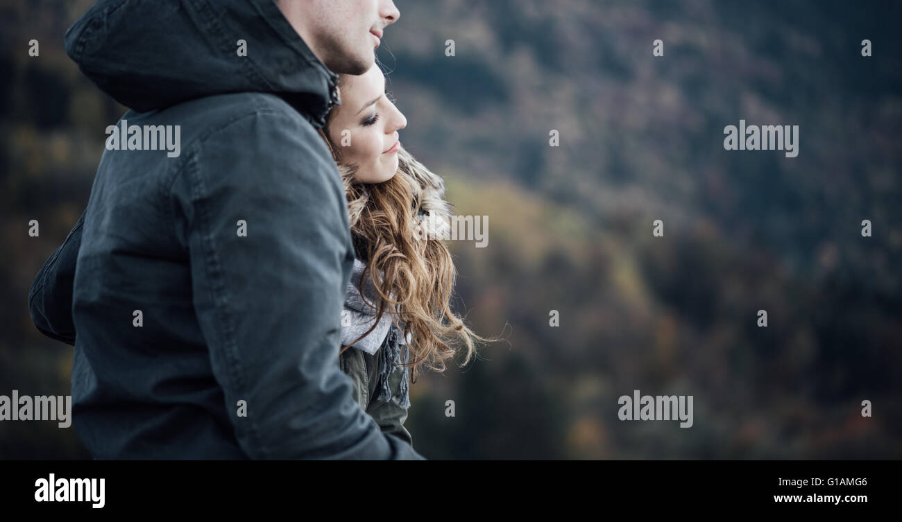 Romantic young couple dating in winter, they are sitting together, she is leaning on her boyfriend's shoulder Stock Photo