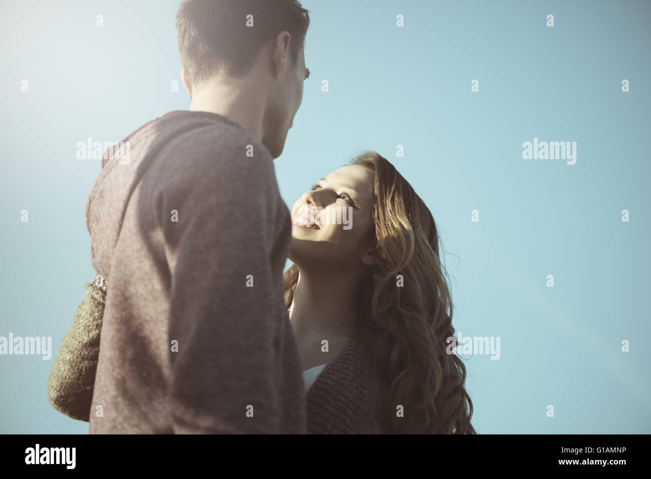 Romantic young teenagers staring at each other against blue sky, love and relationships concept Stock Photo