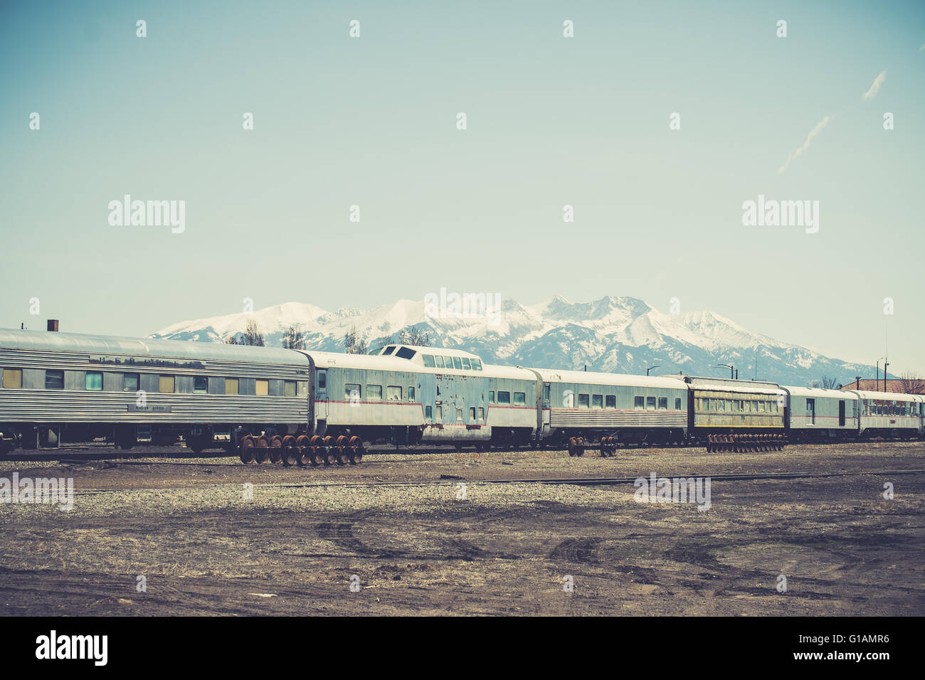 Vintage railroad cars in a siding in Alamosa, Colorado, with snowy Sierra Blanca mountains in the background Stock Photo