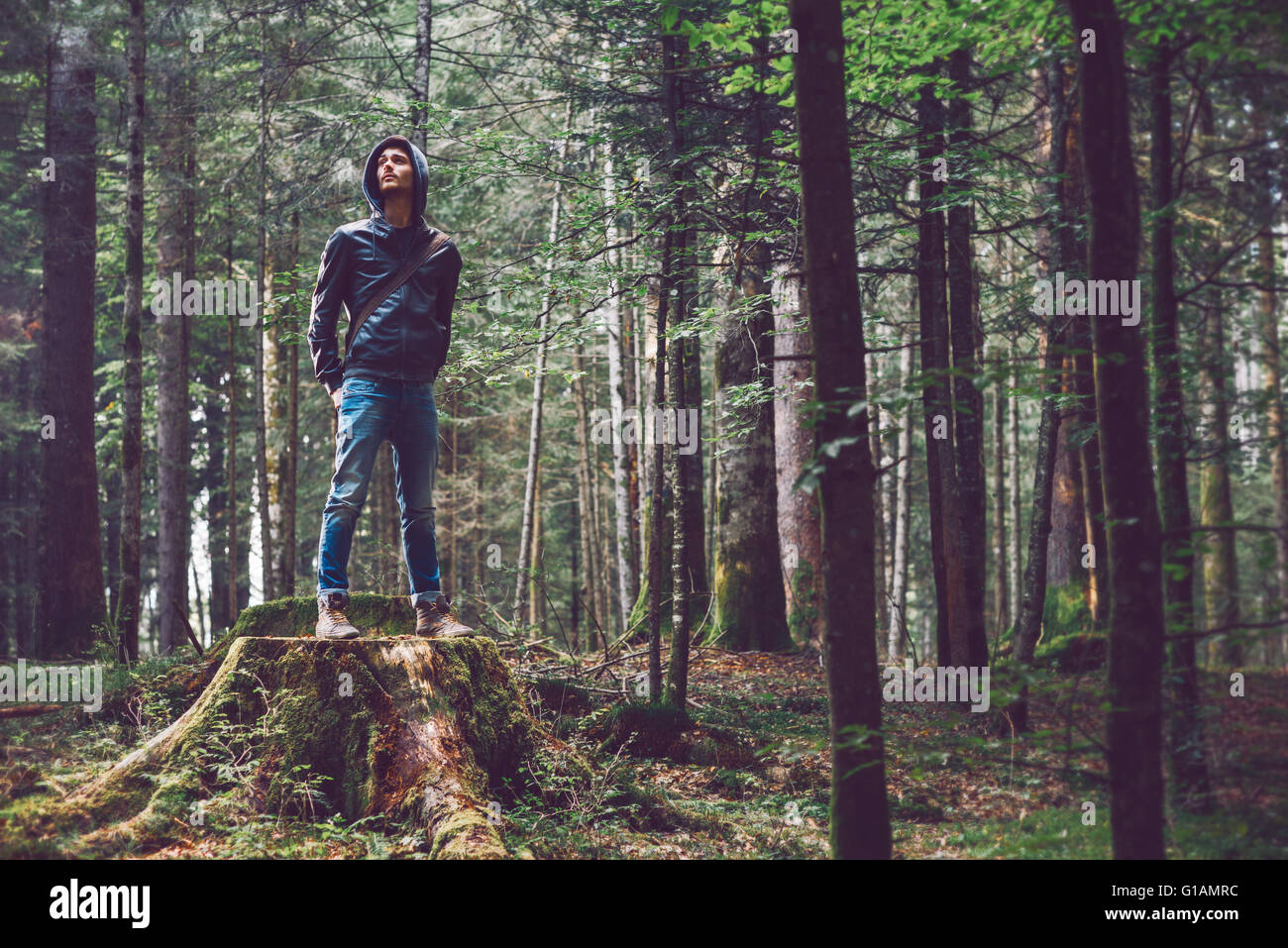 Confident young man standing in the forest, freedom and individuality concept Stock Photo