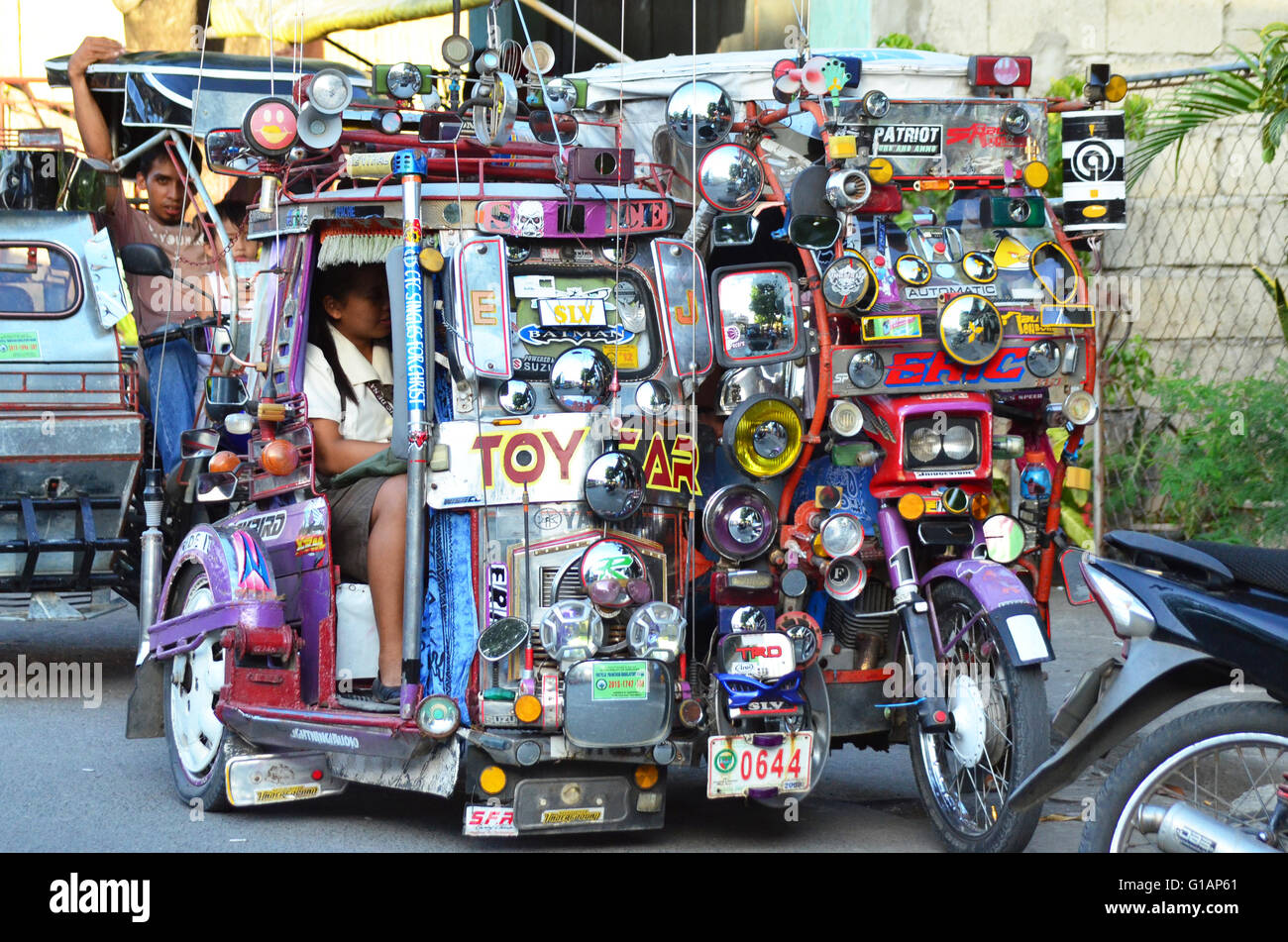 Colorful tricycle with a lot of rear-view mirrors glued on its windshield, Philippines Stock Photo